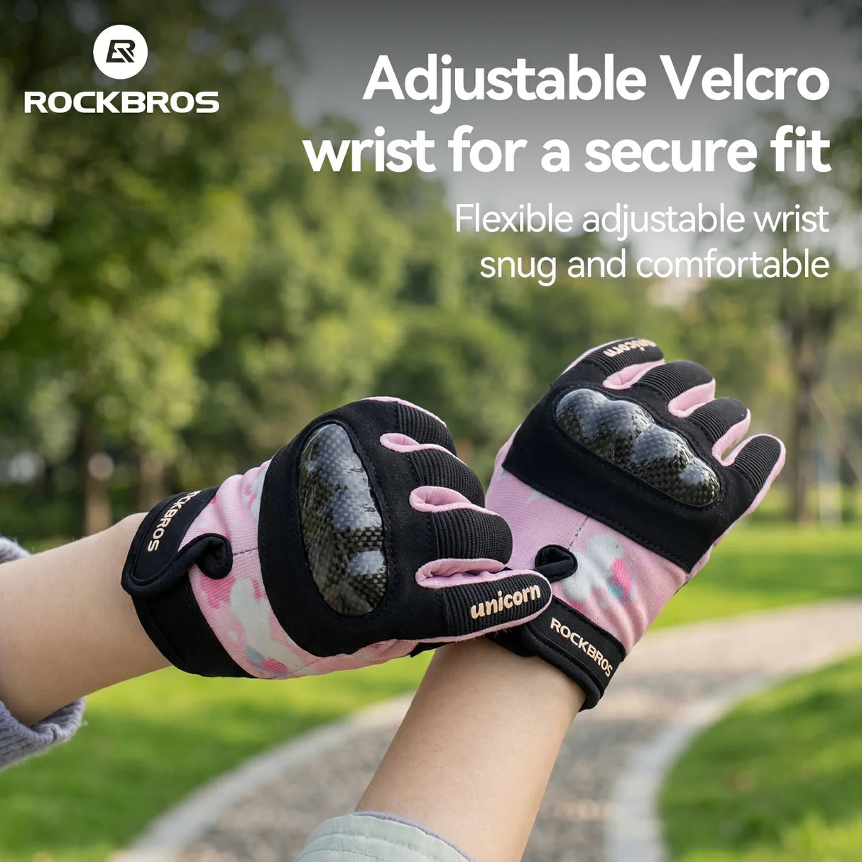 Pink and black gloves with adjustable velcro wrist on a blurred outdoor background