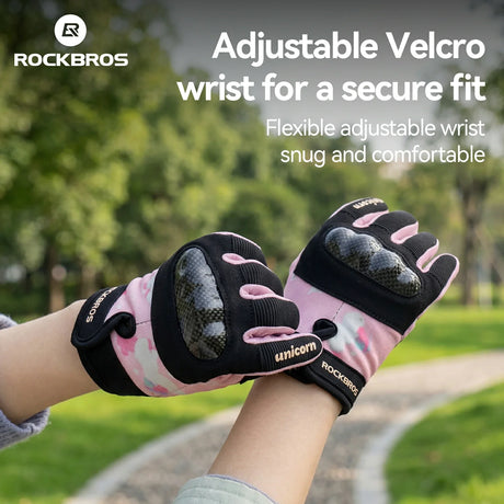 Pink and black gloves with adjustable velcro wrist on a blurred outdoor background