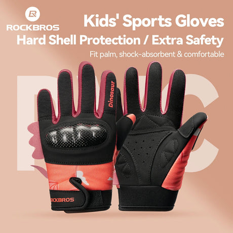 Pair of black and red kids' sports gloves with hard shell protection on a beige background.